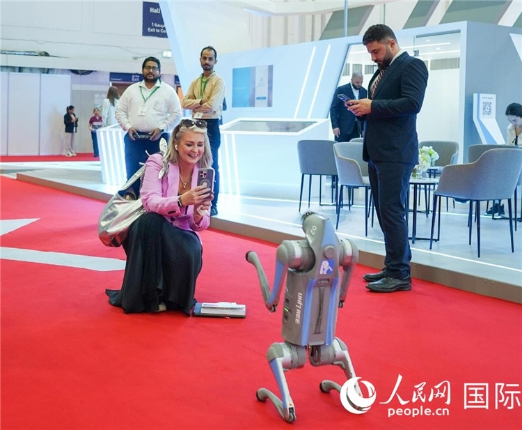 與會(huì)嘉賓被中企機(jī)器人吸引。人民網(wǎng) 塔里克·易卜拉欣攝