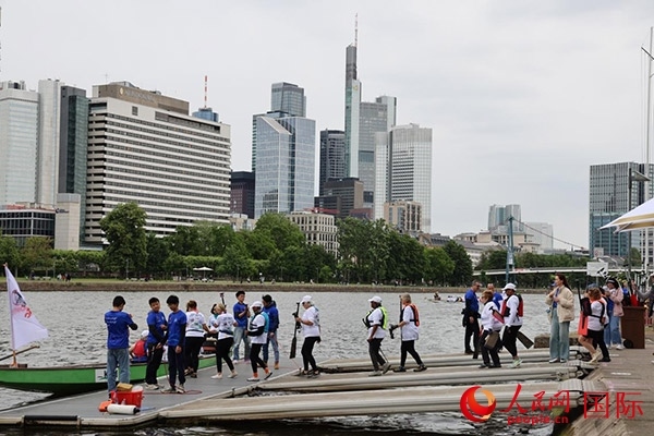 來(lái)自美國(guó)的快樂(lè)龍舟隊(duì)選手們正在登船準(zhǔn)備參賽。人民網(wǎng)記者 劉仲華攝