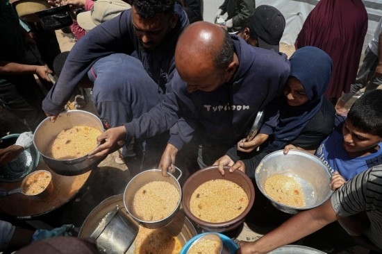 5月28日，人們在加沙城西部的沙提難民營領(lǐng)取救助食物。新華社發(fā)（里澤克·阿卜杜勒賈瓦德攝）