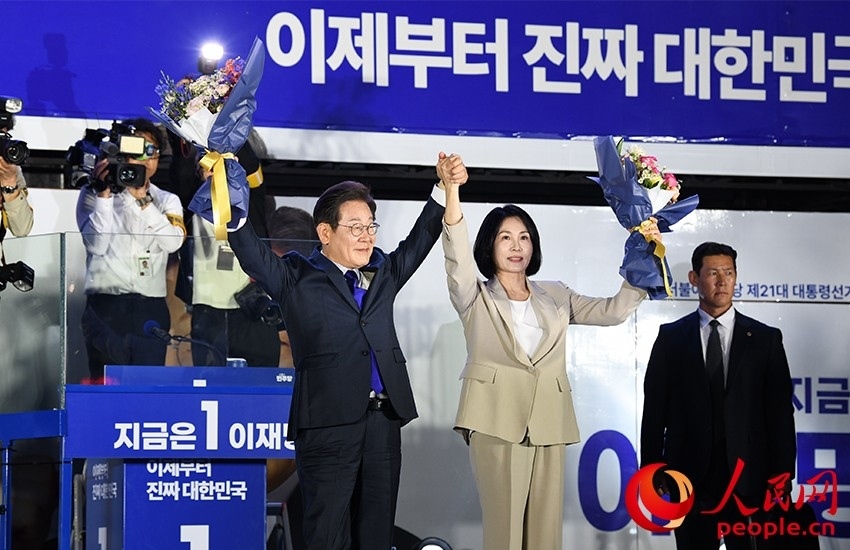 6月4日凌晨，確定當(dāng)選韓國(guó)總統(tǒng)的李在明舉手向歡呼的支持者們致意。 人民網(wǎng) 康炯彬攝